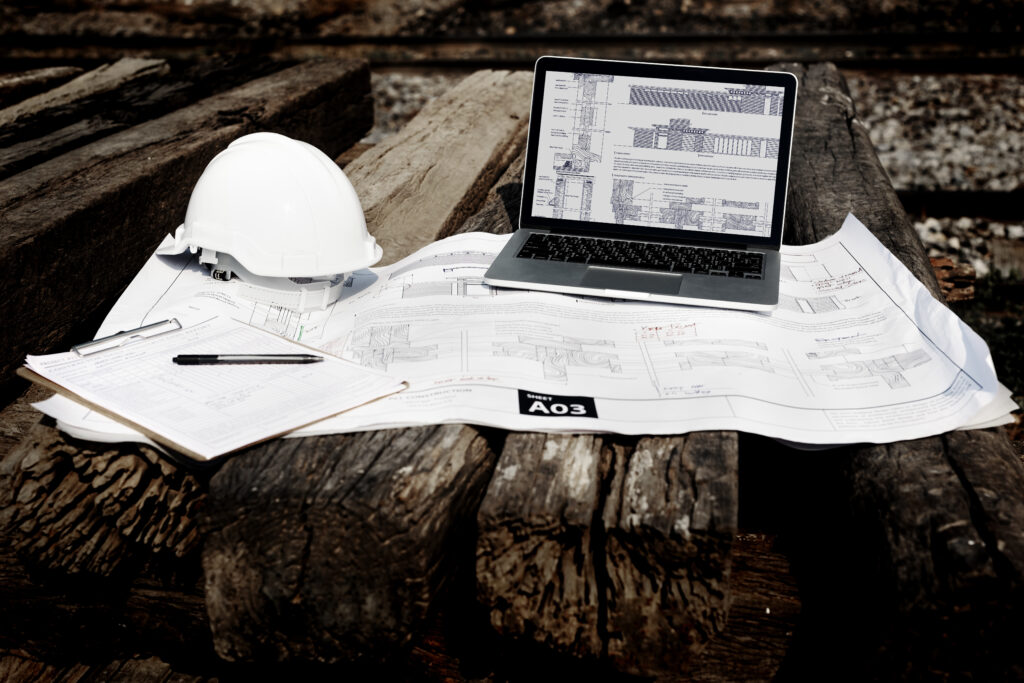 Site supervisor in a hard hat reviewing construction plans.